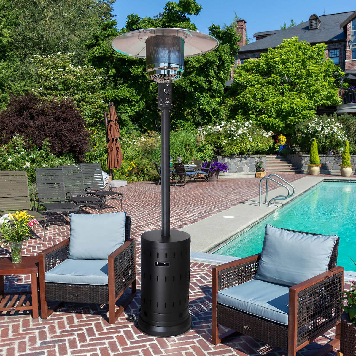 Patio heater with two outdoor chairs next to a pool