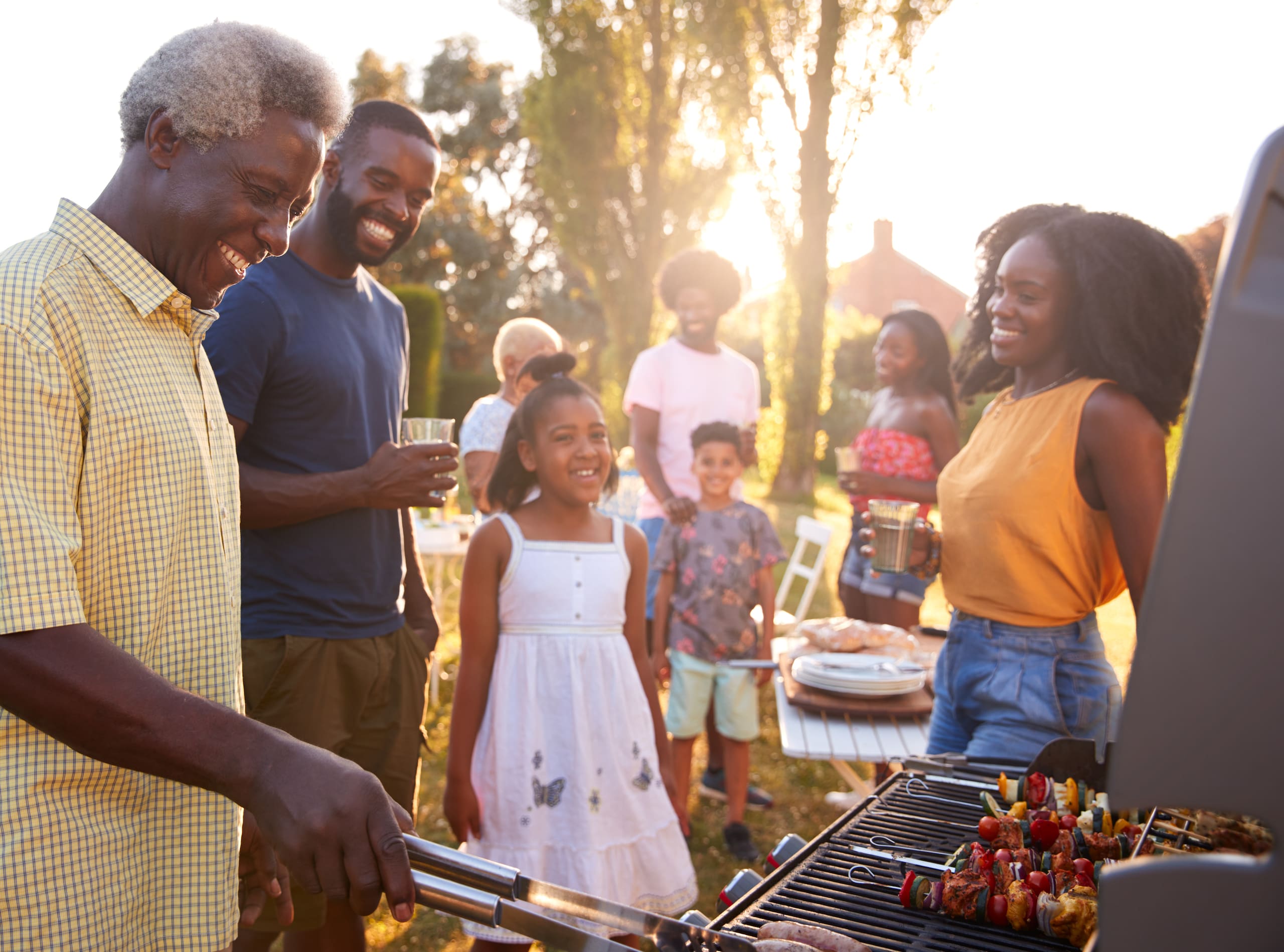 A family gathered outside around a barbecue