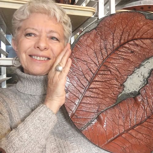 Woman smiling holding pottery