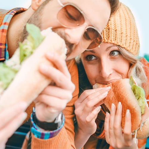 two people eating sandwiches