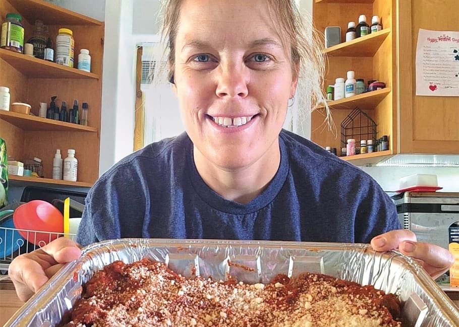 a women holding a pan of lasagna