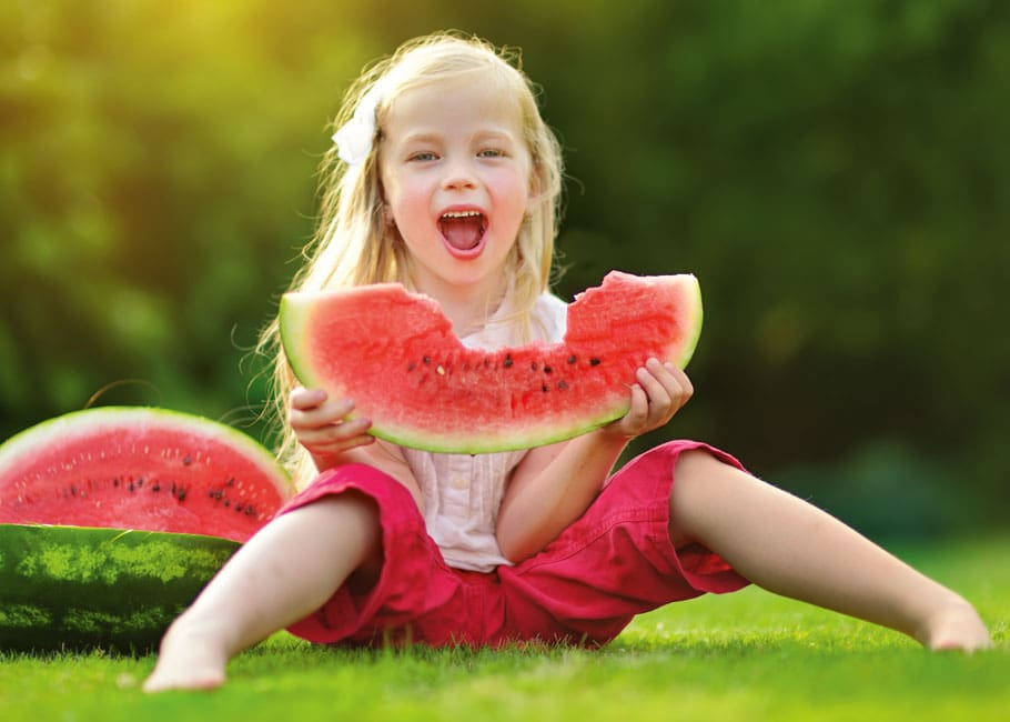little girl holding a huge watermelon slice