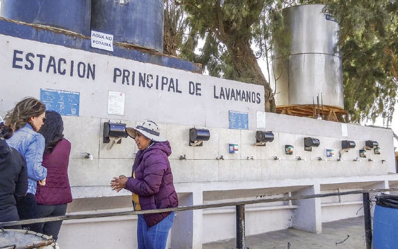 people at a hand-washing station