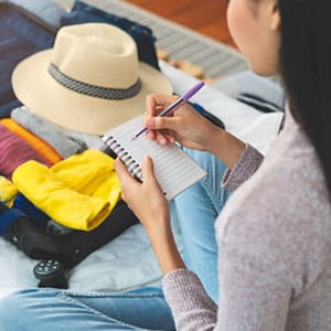 Woman packing and checking off her to-do list