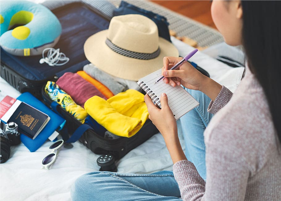 Woman packing and checking off things on a checklist