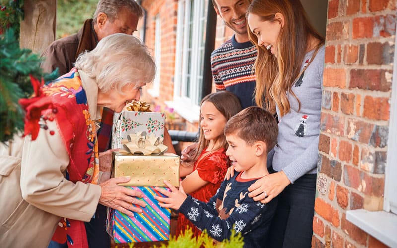 adults handing gifts to kids