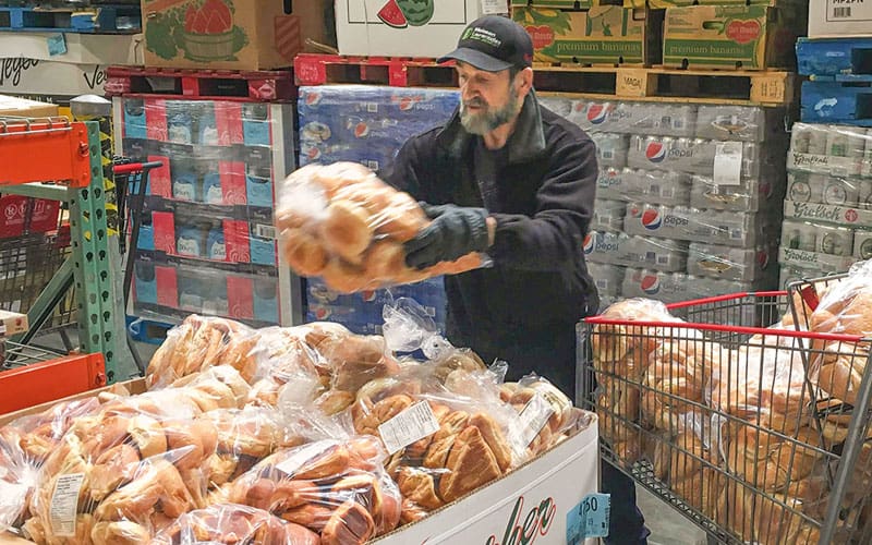 A volunteer from the food bank Moisson Laurentides picks up bread donations from a Montreal-area Costco.