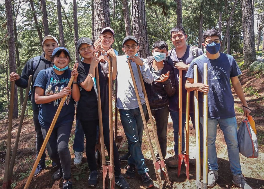 Scholarship students give back by planting trees; Tulio García, president of the Juan Francisco García Comparini Foundation (second from right) visiting farmers.