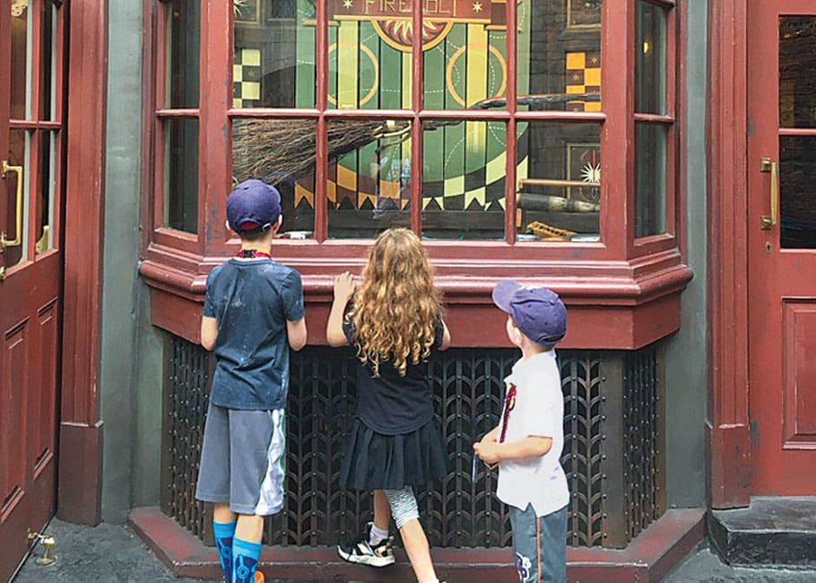 3 kids looking through a window