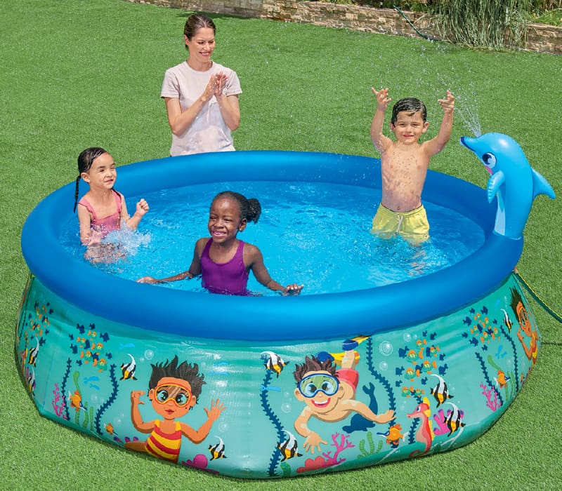 pool with 3 children playing in it and adult standing poolside