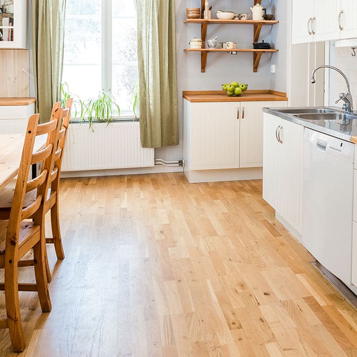 Well lit, farmhouse styled small kitchen with wood accents, white cabinetry and oak flooring.