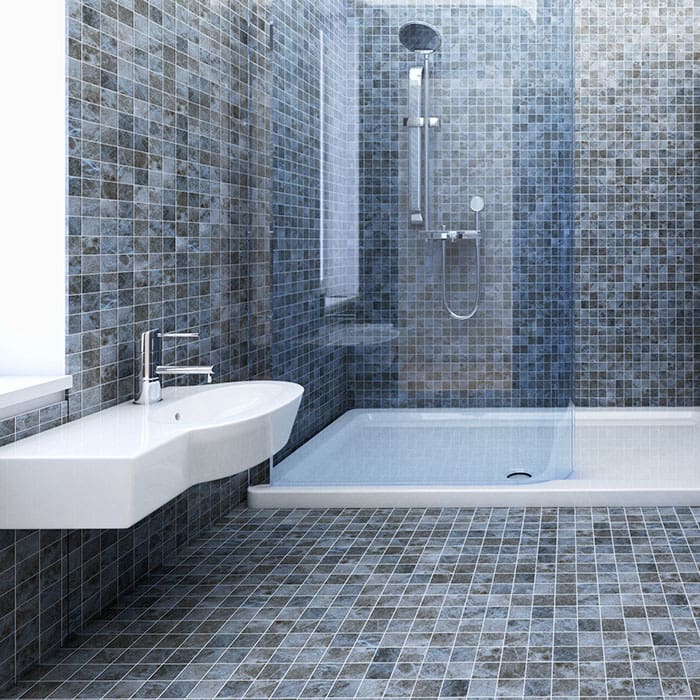 A wonderfully modern, open shower area replete with floating white procelain sink. Floor-to-ceiling small, square blue and gray hued tiles reside throught.