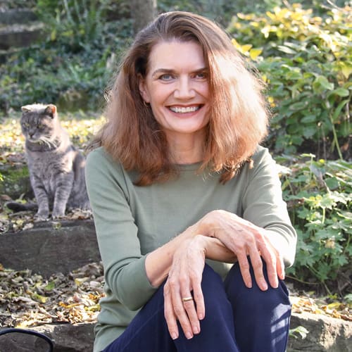 woman in front of woods smiling