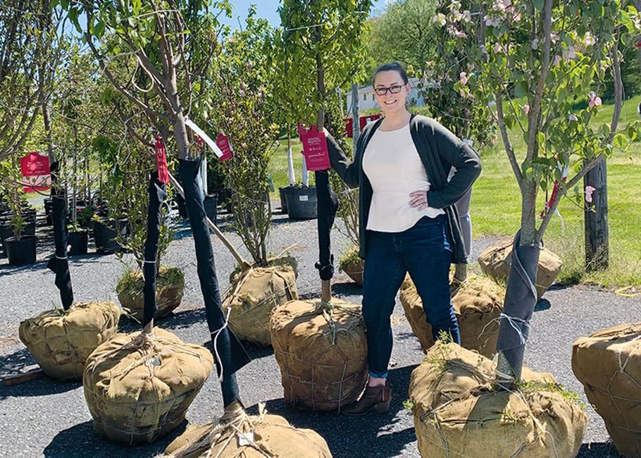 woman in front of trees about to be planted