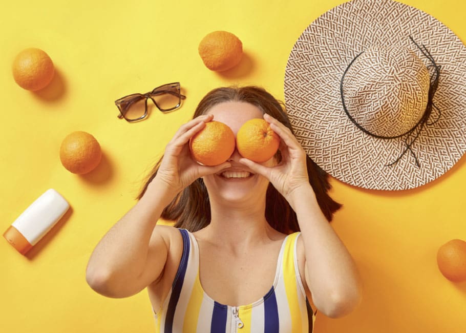 woman holding oranges infront of her eyes