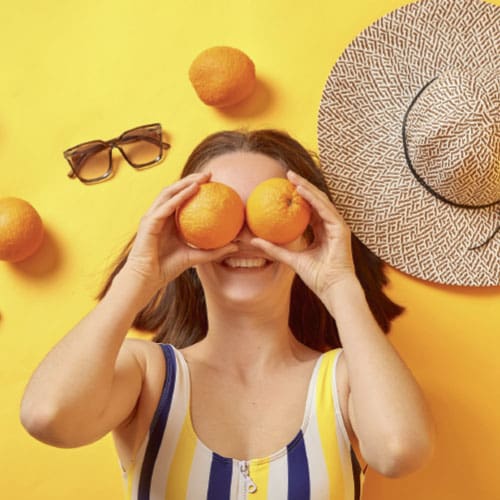 woman with oranges over her eyes