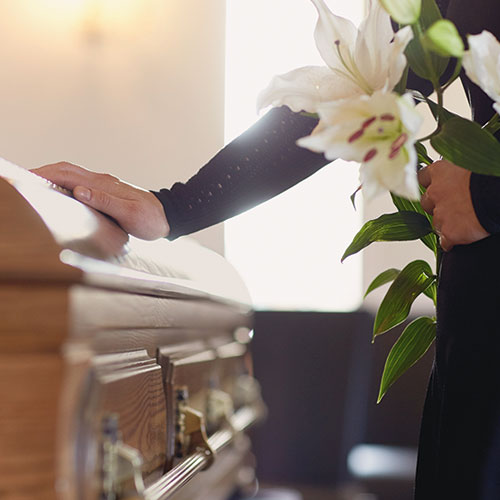 a persons hand on a coffin