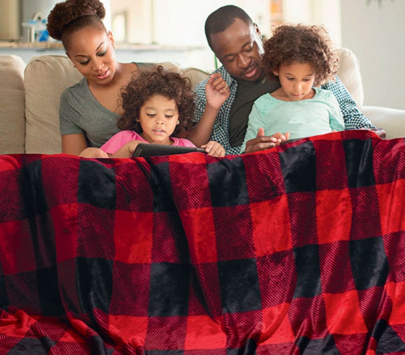 a family holding a plaid blanket
