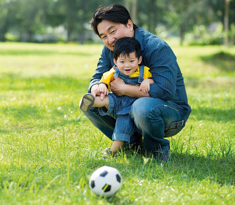 father and young son with soccerball