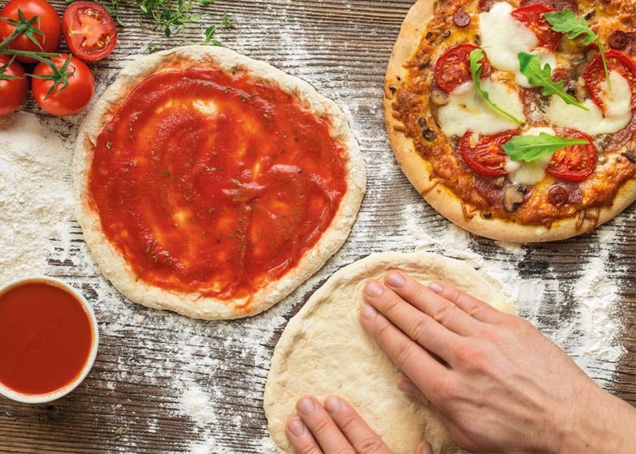 hands making pizza