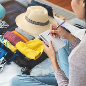 woman packing a bag with a checklist in hand