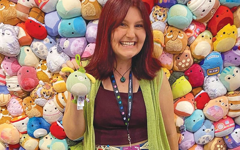 a woman surrounded by Squishmallows