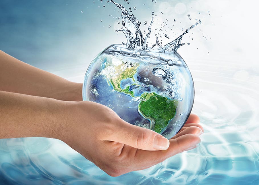 hands holding a clear vase of water